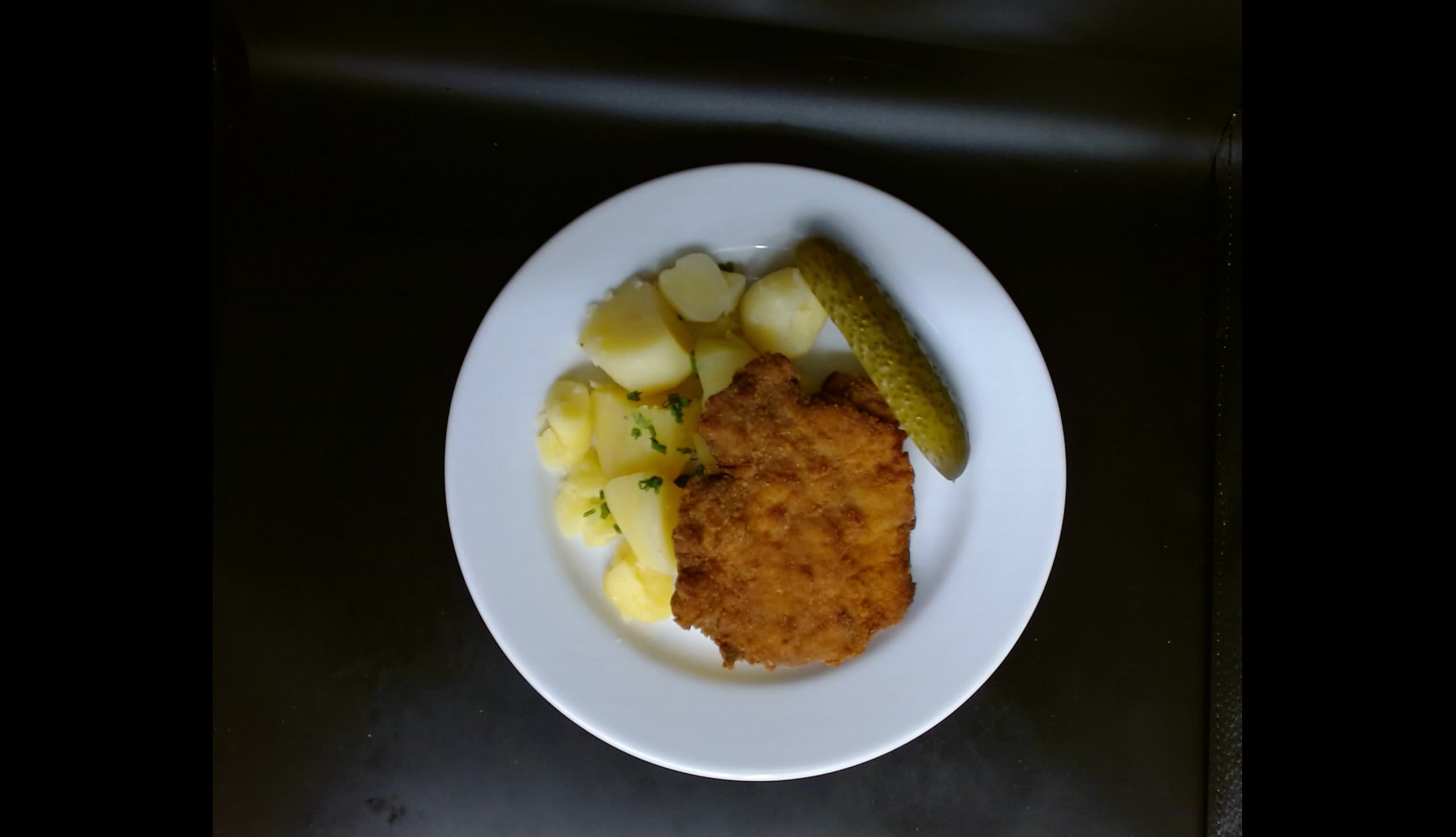 Smažený vepřový řízek,vařené brambory, okurka